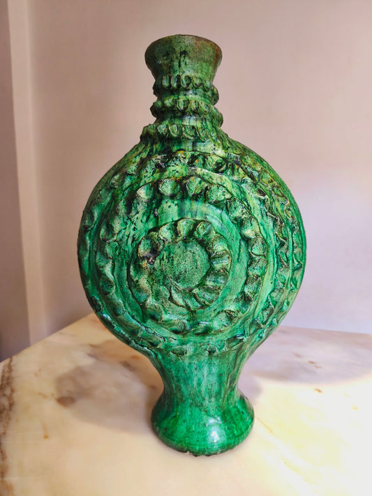 Antique Moroccan green ceramic candle holder, tall textured relief, 50 cm height, on a marble surface.