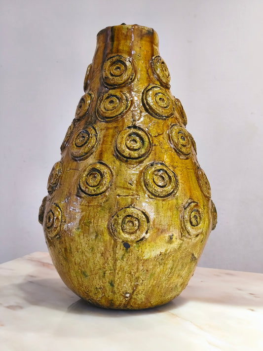 Decorative ceramic vase with circular patterns on a white surface