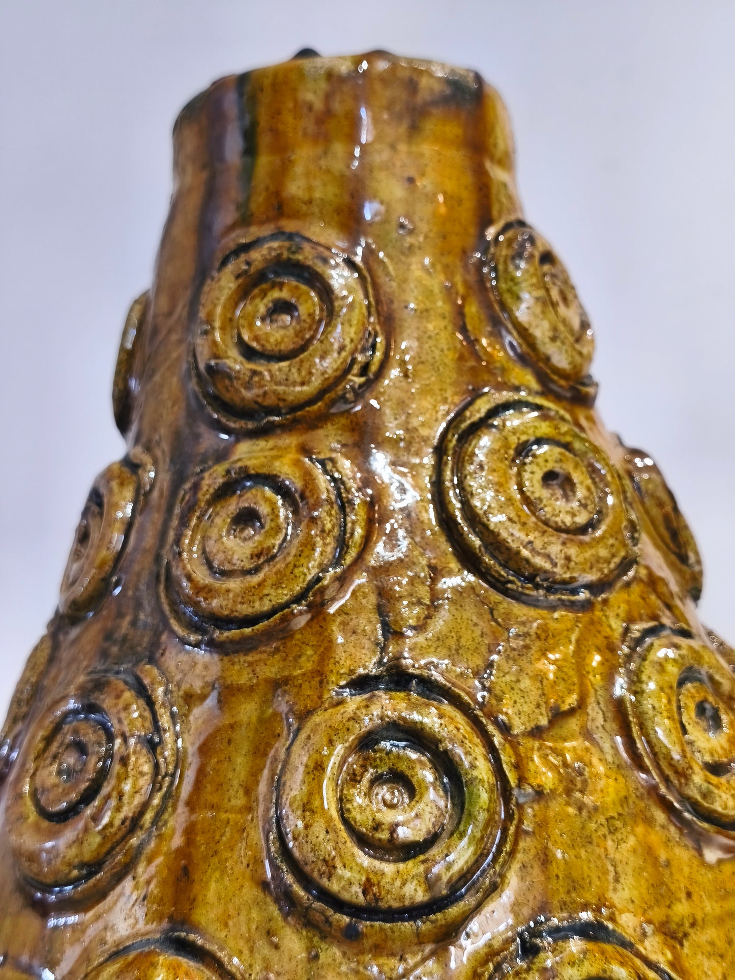 Close-up of a ceramic vase with circular patterns on a white background
