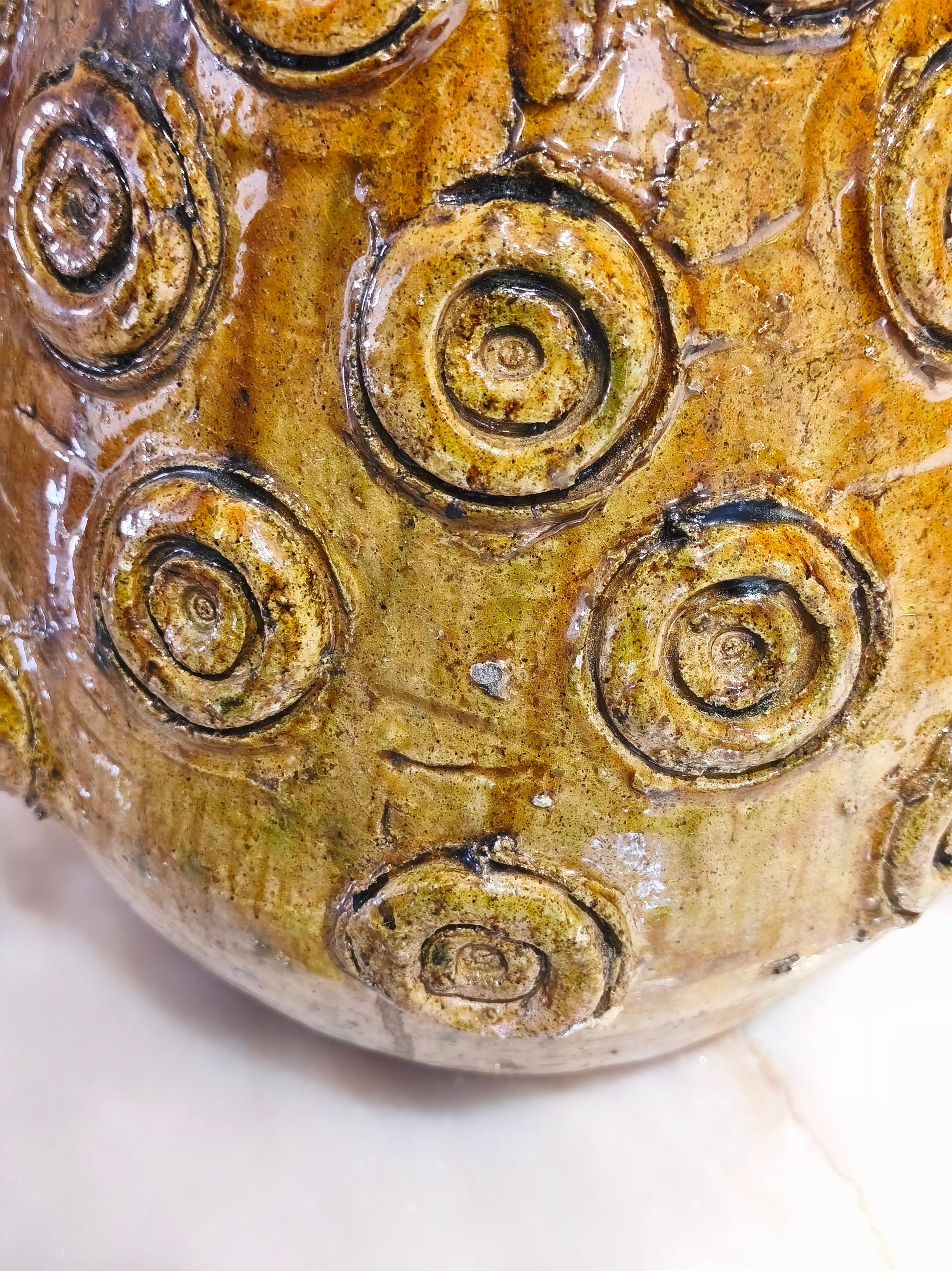 Close-up of a ceramic ball with spiral patterns on a white background