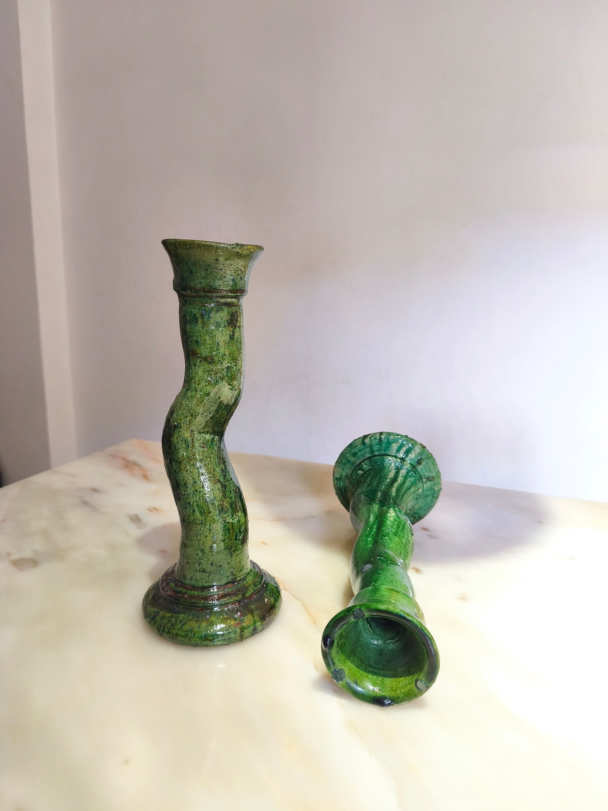 Close-up of handmade Moroccan green ceramic candlestick with glossy glaze and imperfections